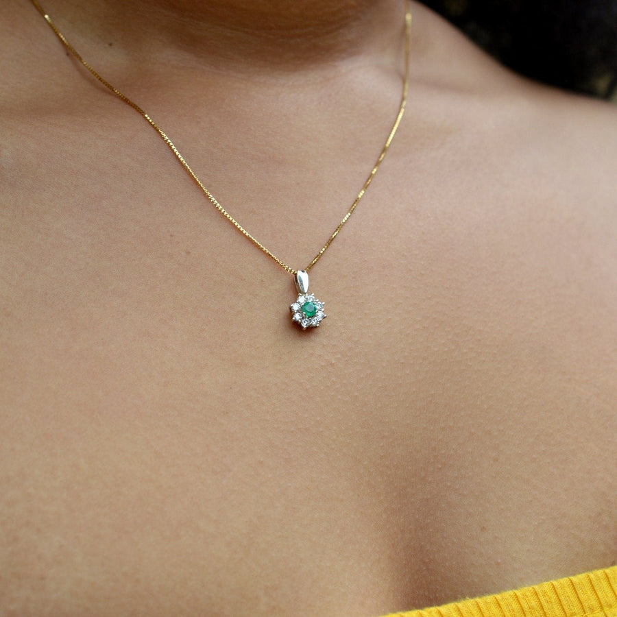 Vintage-Anhänger aus 18 Karat Weißgold mit Smaragd und Diamanten, der an einer Goldkette getragen wird und sein elegantes Design unterstreicht.