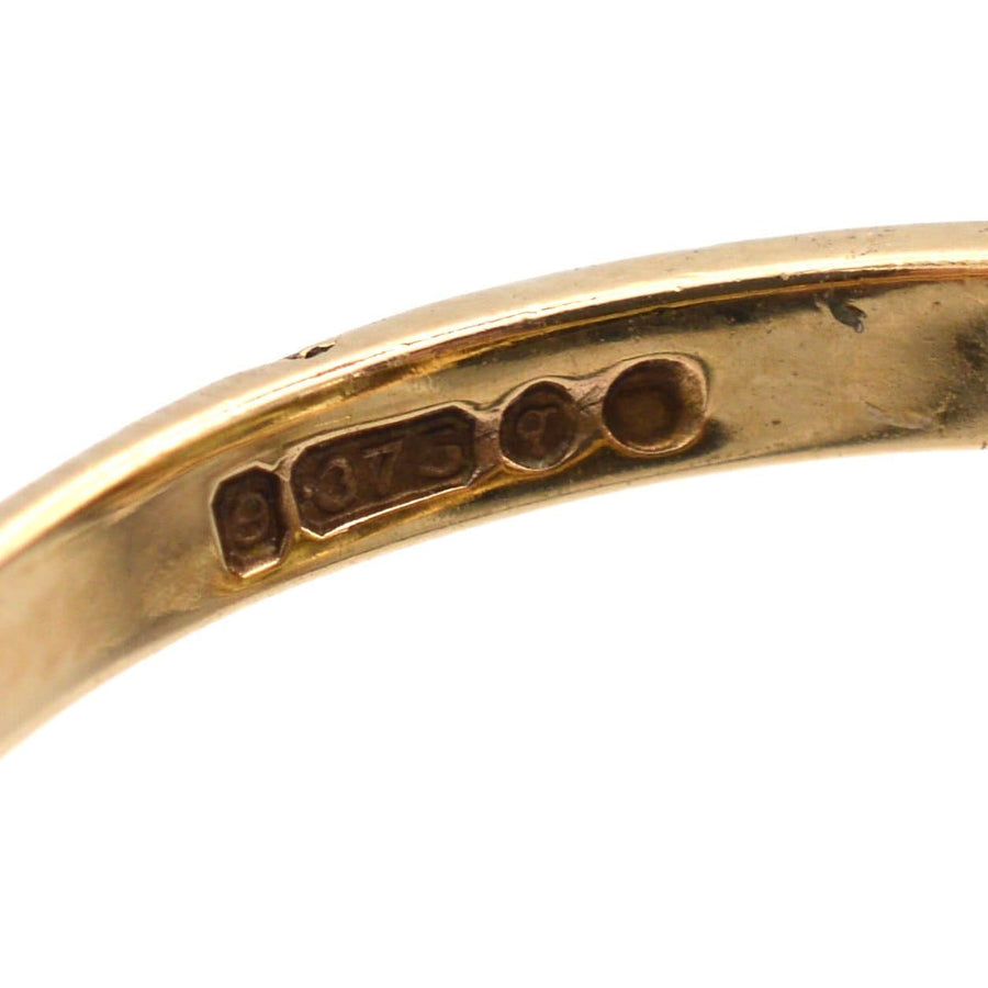 Nahaufnahme der Prüfzeichen aus 9-karätigem Gold auf einem alten Ring, die seine Authentizität und Handwerkskunst unterstreichen.