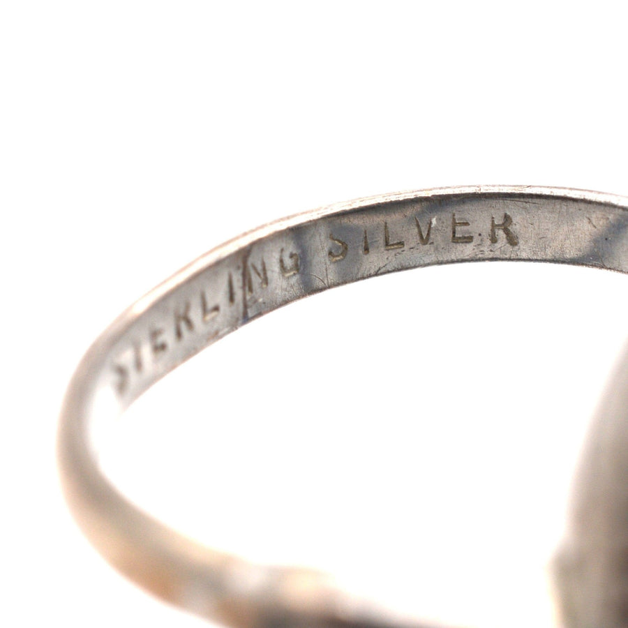 Nahaufnahme des Innenrings eines alten Silberrings, der die Gravur "Sterling Silver" zeigt.