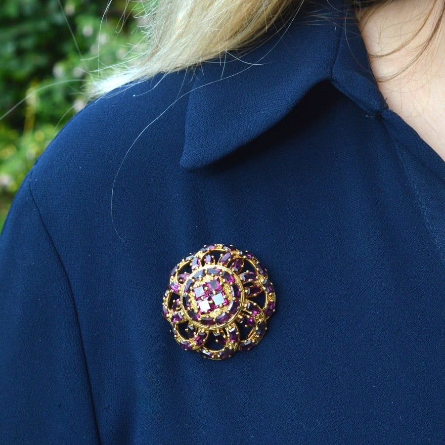 19th century French gold brooch with rhodolite garnets, worn on a navy blue garment.