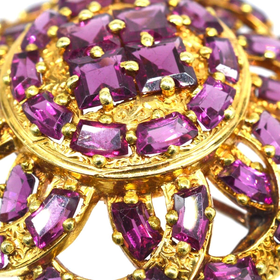 19th century French gold brooch pendant featuring rhodolite garnets in floral design, symbolizing love and passion.