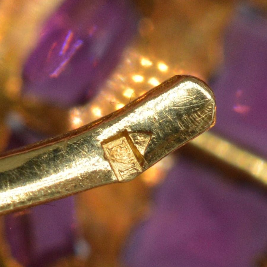 Close-up of stamp on 19th century gold brooch showcasing craftsmanship and authenticity.