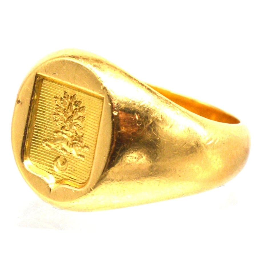 Antique French 18ct gold signet ring with hand-engraved armorial shield featuring a lion and tree, showcasing buttery gold.