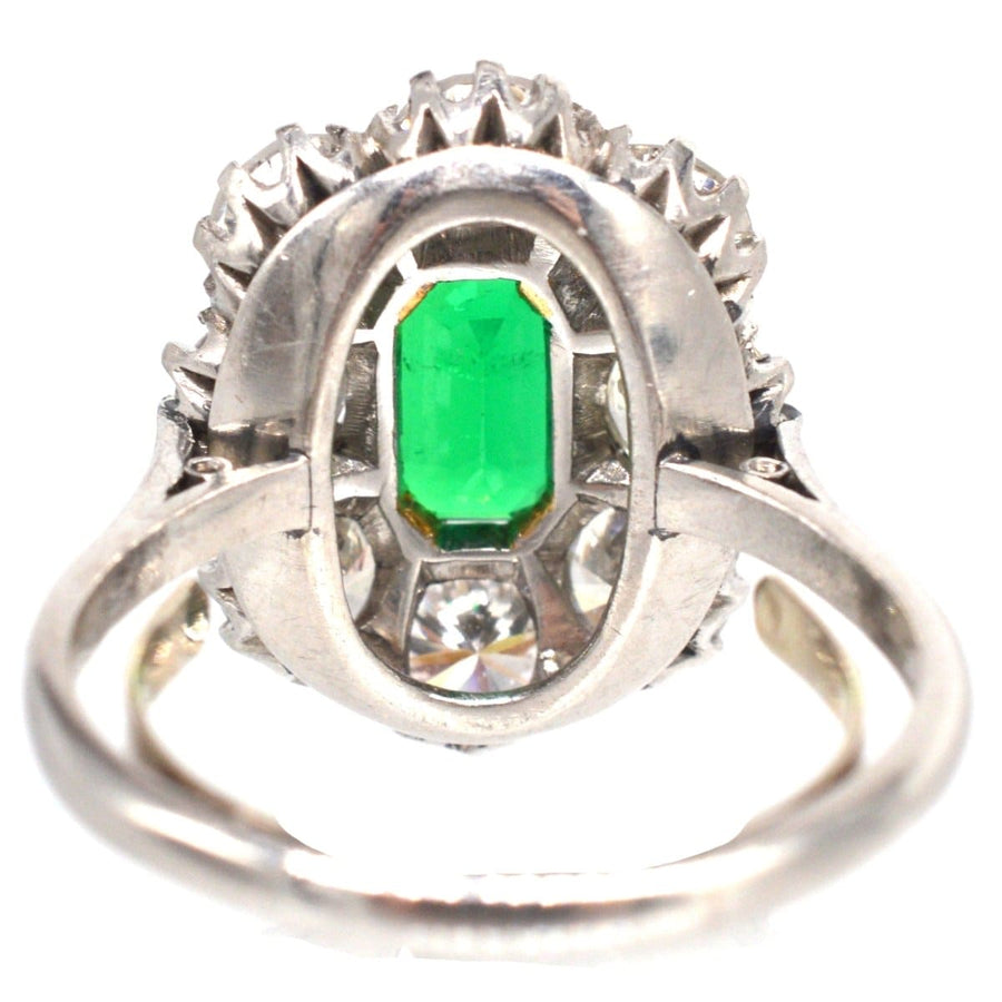 Art Deco gold and platinum ring featuring a Columbian emerald and diamond cluster, showcasing an elegant design.