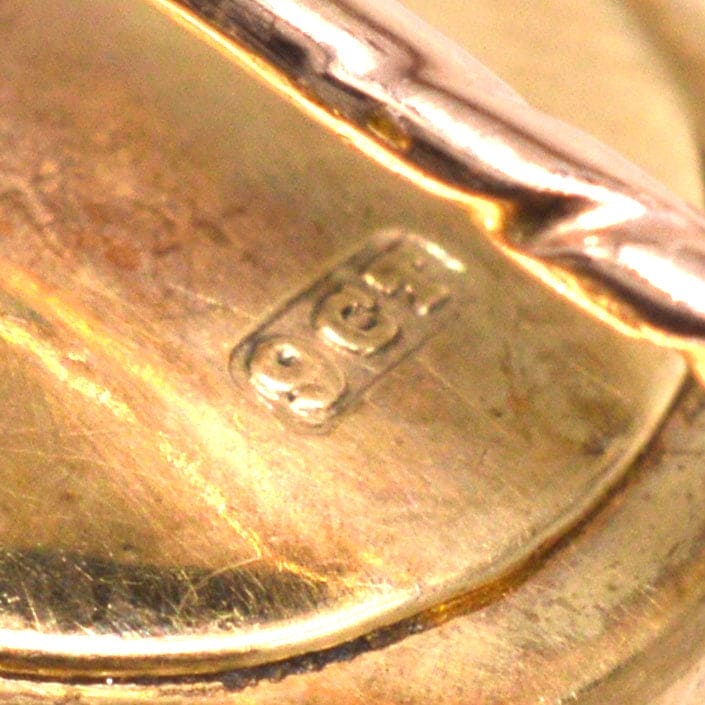 Close-up of 9ct gold stamp on fishing lure tie pin, showcasing quality and craftsmanship.