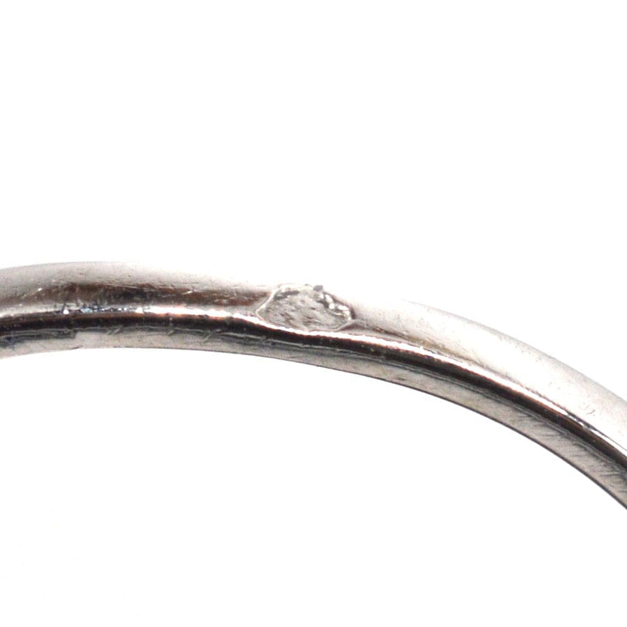 Close-up of the interior of a platinum ring showing a stamp and detailed craftsmanship.