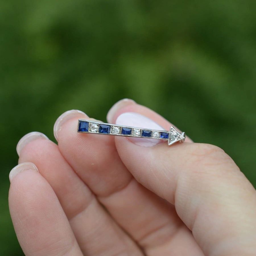 Art Deco French arrow brooch featuring sapphires and diamonds, elegantly styled for lapel wear.