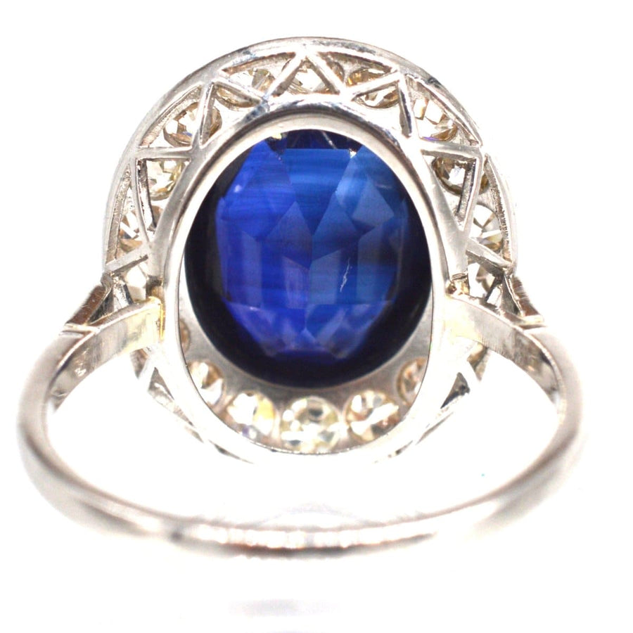 Art Deco platinum ring featuring a synthetic sapphire centerpiece and diamond accents in a vintage design.