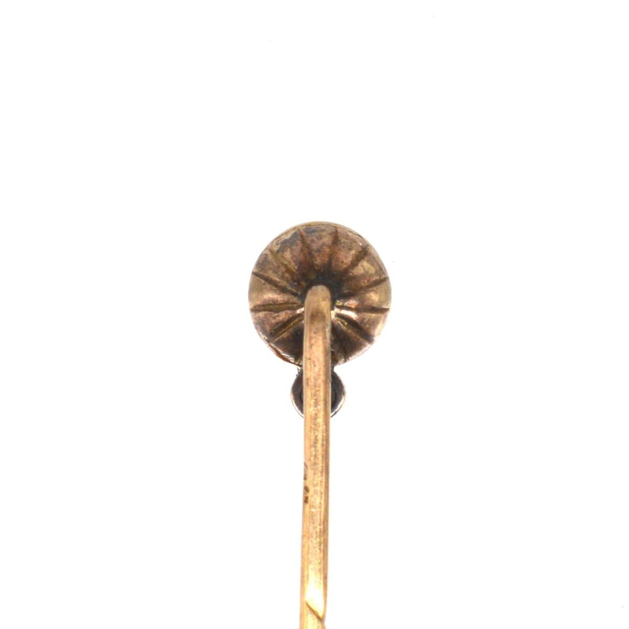 Close-up of an Edwardian 14ct gold tie pin, featuring a hallmarked classic design and natural pearl accent.