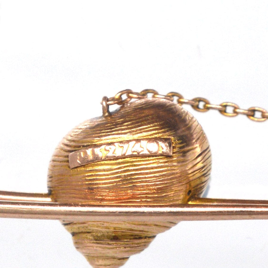 Close-up of a vintage Edwardian 15ct gold bar brooch featuring a seashell design with a natural pearl chain.
