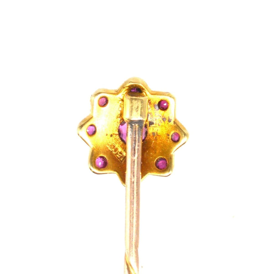 Edwardian 15ct gold tie pin designed as a flower with garnets and seed pearls, perfect for enhancing silk ties.