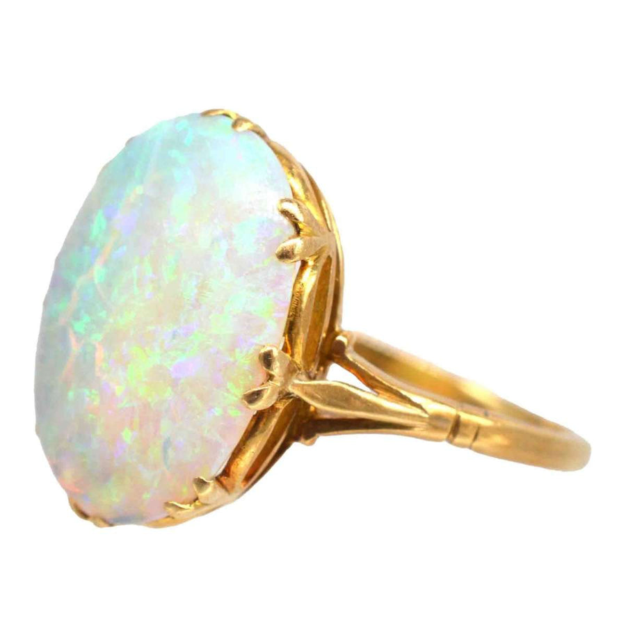 Edwardian 18ct gold large opal ring showcasing vibrant green and blue hues, elegantly designed with a stunning gemstone.