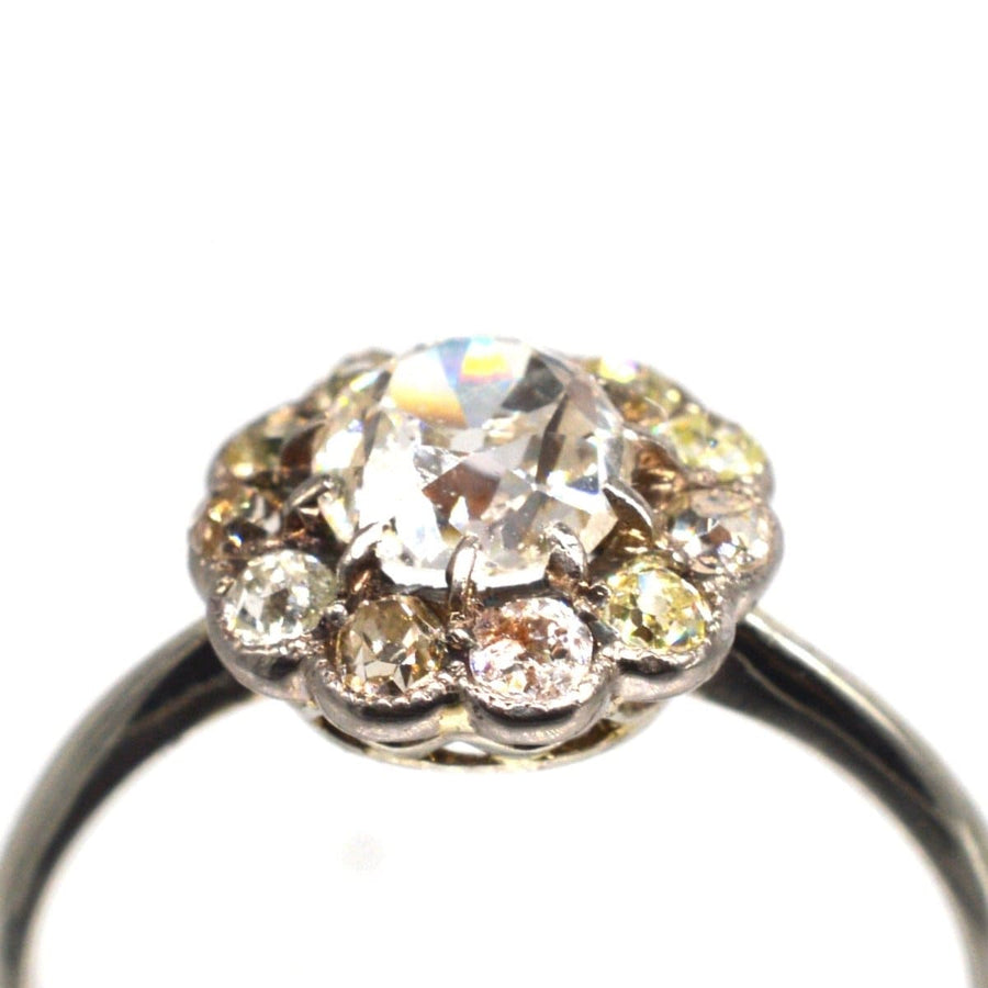 Edwardian 18ct white gold ring featuring a large old mine cut diamond cluster with tinted surrounding diamonds.