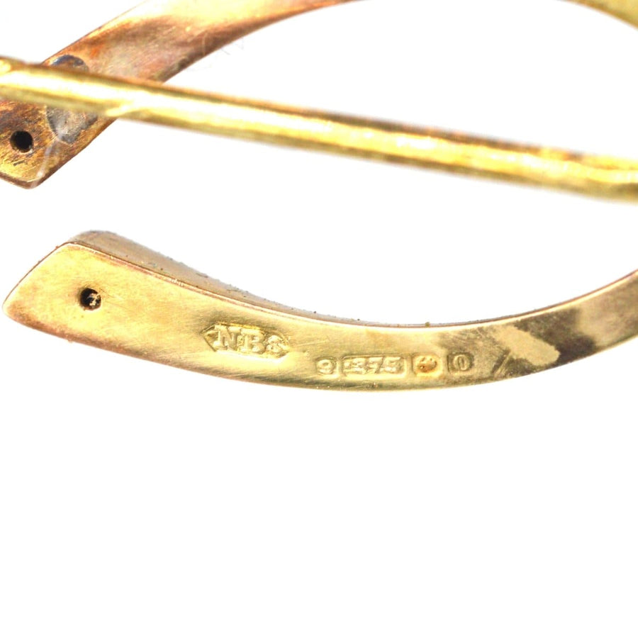 Close-up of hallmarks on a 9ct gold tie pin showcasing Nathan Brothers mark and gold composition.