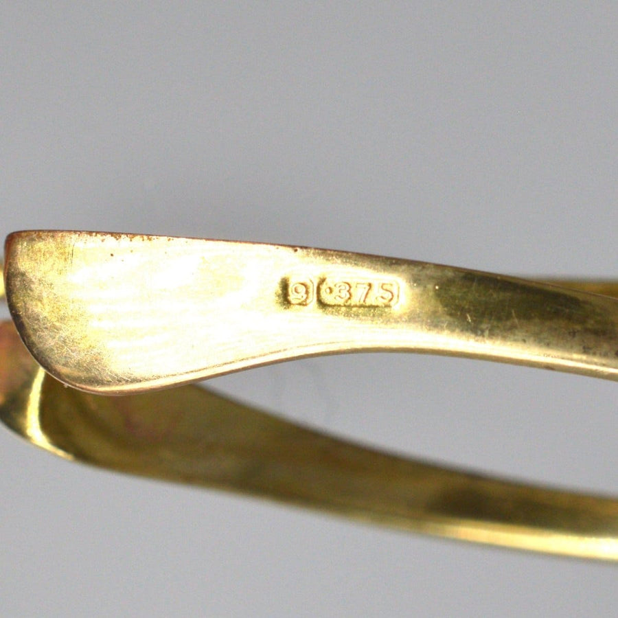 Close-up of a hallmarked 9ct gold tie pin showcasing the stamp and gold content.