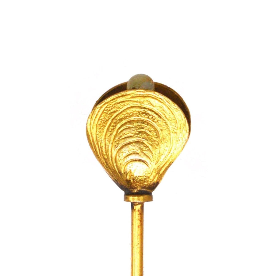 Edwardian 9ct gold oyster shell hat pin with pearl detail, showcasing ornate design and period charm.