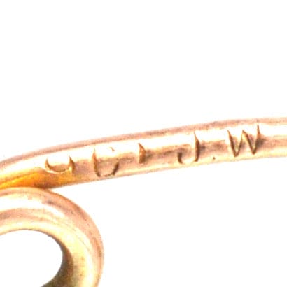 Close-up of stamp engraving on Edwardian 9ct gold Stafford Knot bar brooch, showcasing its authenticity and craftsmanship.