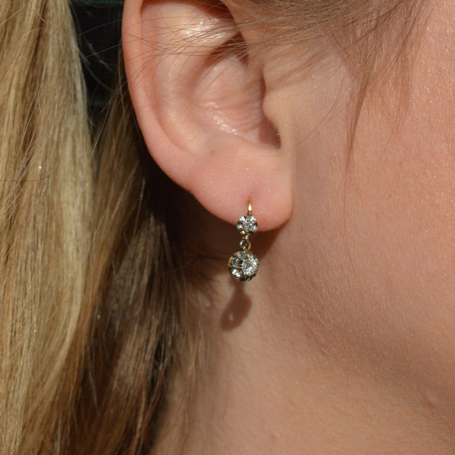 French Belle Epoque 18ct gold and platinum diamond drop "Dormeuse" earrings worn in a model's ear.