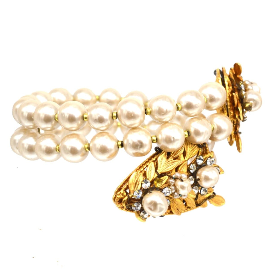 Miriam Haskell white paste and faux pearl open bangle featuring a gold serpent design and lustrous faux pearls.