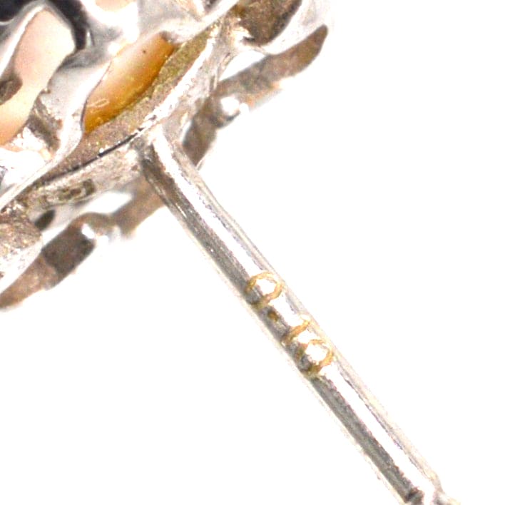 Close-up of a 9ct white gold earring post showcasing intricate detailing and stamp.