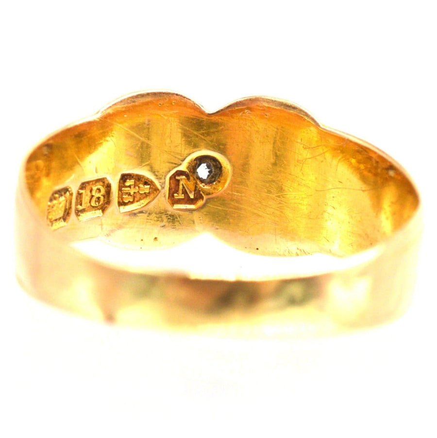 Close-up of the inner band of a Victorian 18ct gold Kiss ring, featuring stamp details.