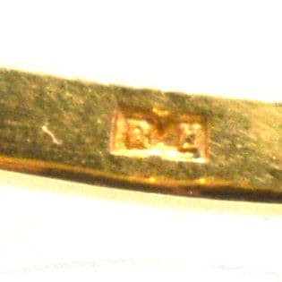 Close-up of stamp on vintage 18ct gold ring, indicating authenticity and gold content.