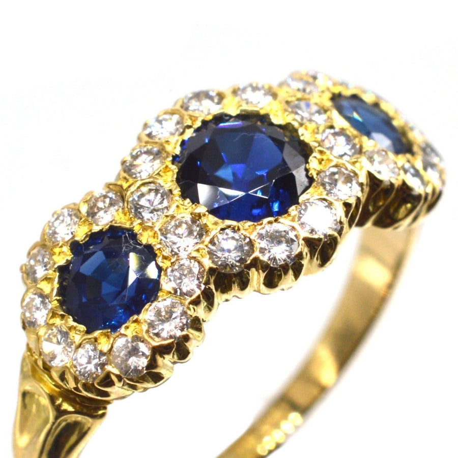 Vintage 18ct gold ring featuring three vibrant sapphires and diamond clusters, perfect for an engagement or special gift.