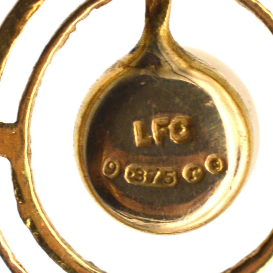 Close-up of 1970s 9ct gold pendant stamp and purity stamp, showcasing vintage craftsmanship.