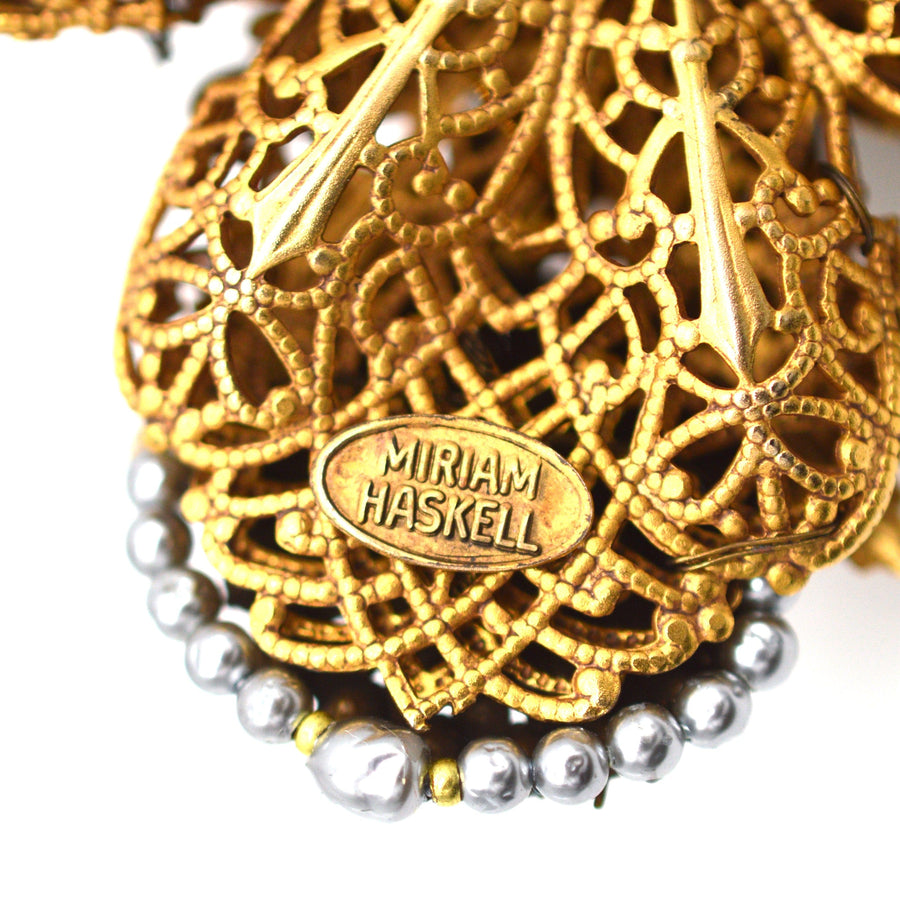 Close-up of Miriam Haskell gold gilt necklace with black pearls and rhinestones, showcasing intricate design and signature.