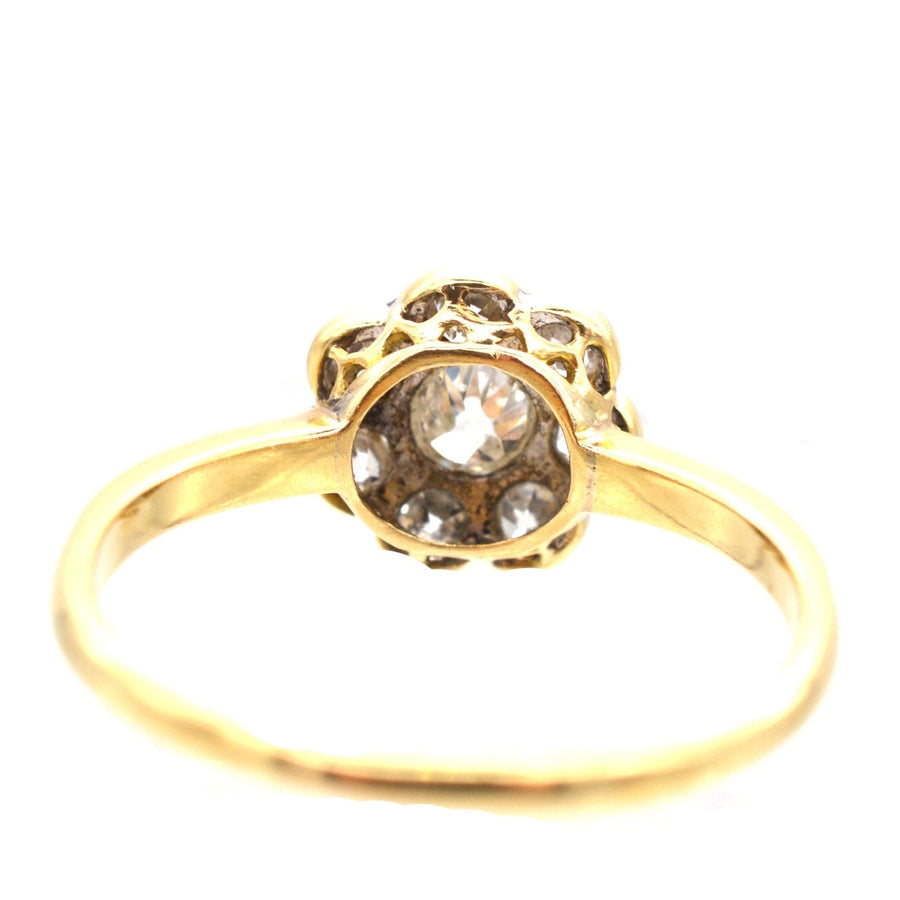 Art Deco 18ct gold and platinum diamond cluster ring featuring a central 0.20 carat diamond and surrounding diamonds.