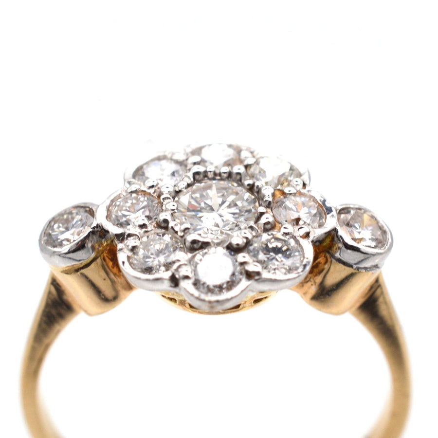 Art Deco 18ct gold and platinum diamond cluster ring featuring a central diamond surrounded by eight smaller stones.