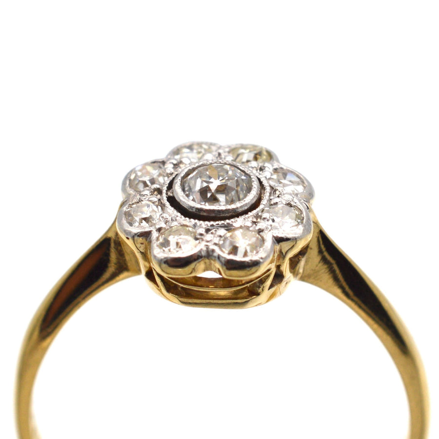 Art Deco 18ct gold and platinum diamond cluster ring, featuring a central 0.10ct diamond and a millegrain setting.