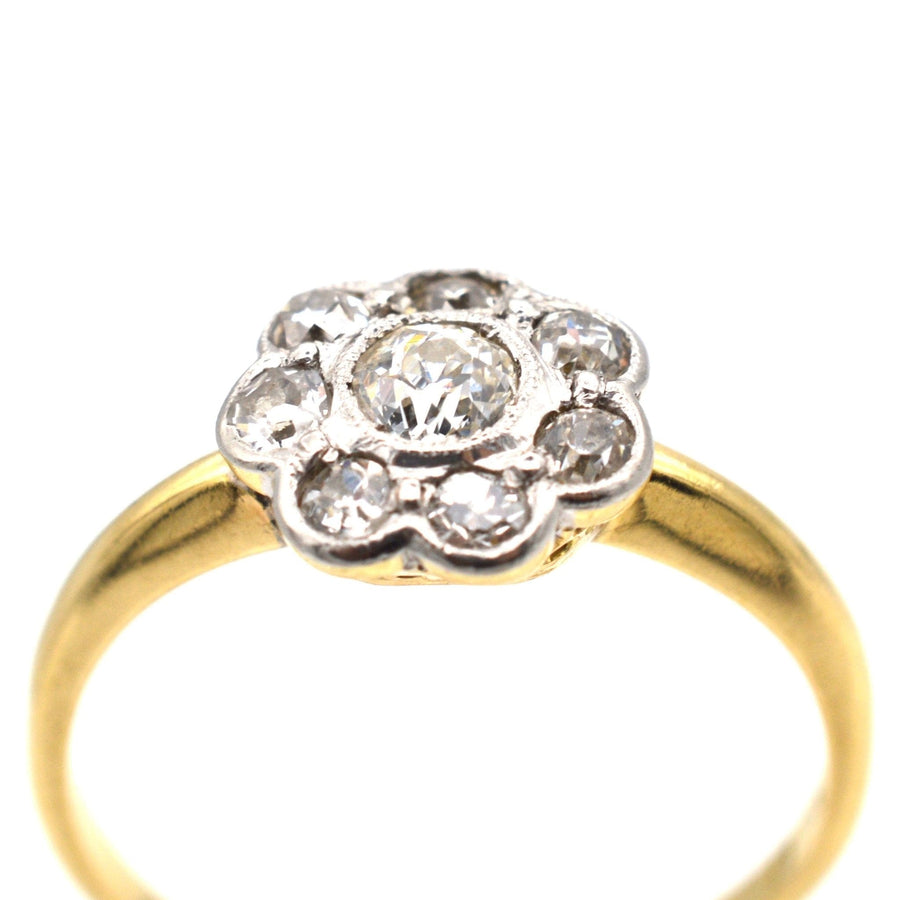 Art Deco 18ct gold and platinum diamond cluster ring featuring a center diamond and surrounding cluster.