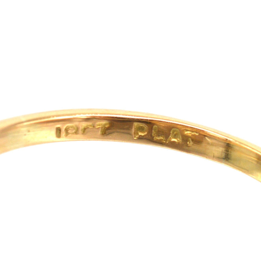 Close-up of the inner band of an Art Deco gold and platinum diamond ring showing 18ct and platinum marking.