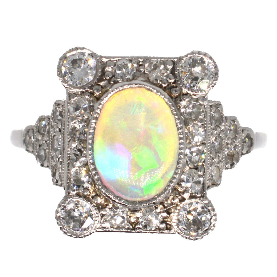 Art Deco 18ct gold and platinum ring featuring an opal center and surrounded by diamonds in intricate setting.