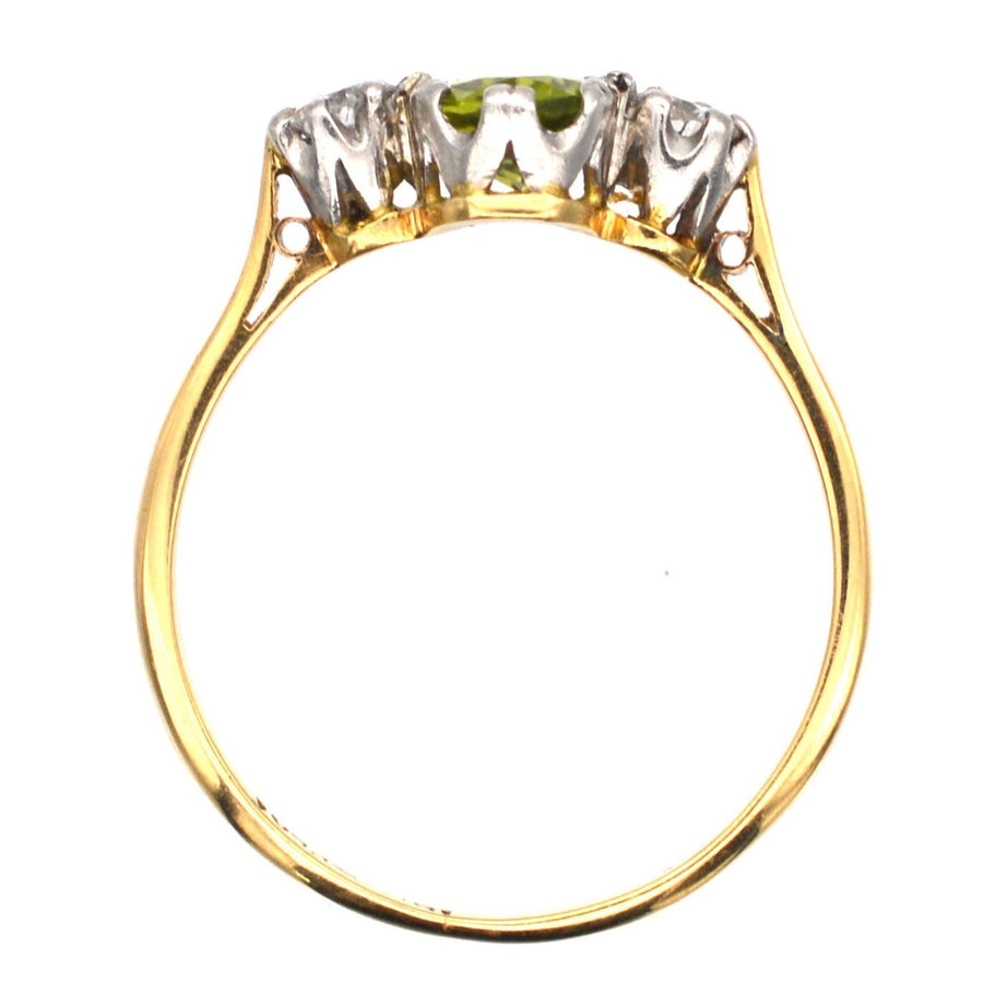 Art Deco 18ct gold and platinum three stone peridot and diamond ring, displaying olive green peridot and sparkling diamonds.