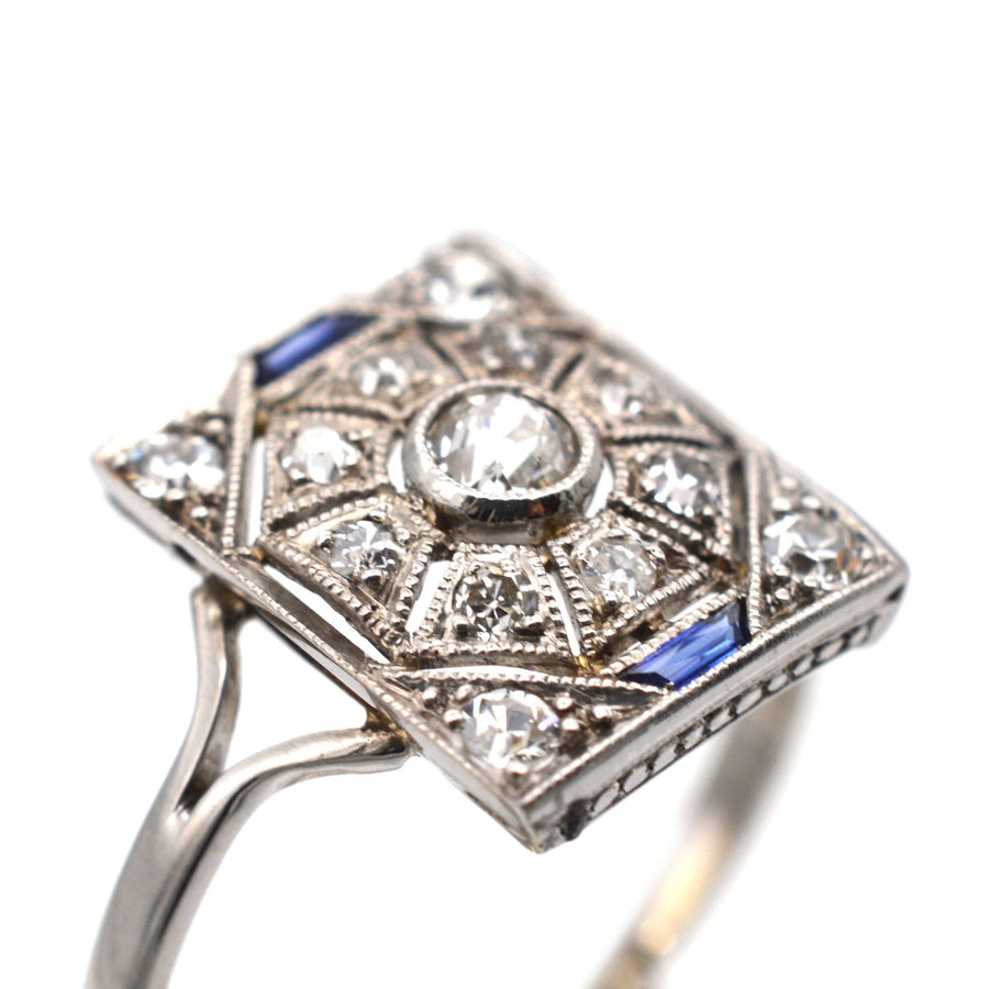 Art Deco 18ct white gold & platinum ring with diamonds and sapphires, featuring bold geometric design.
