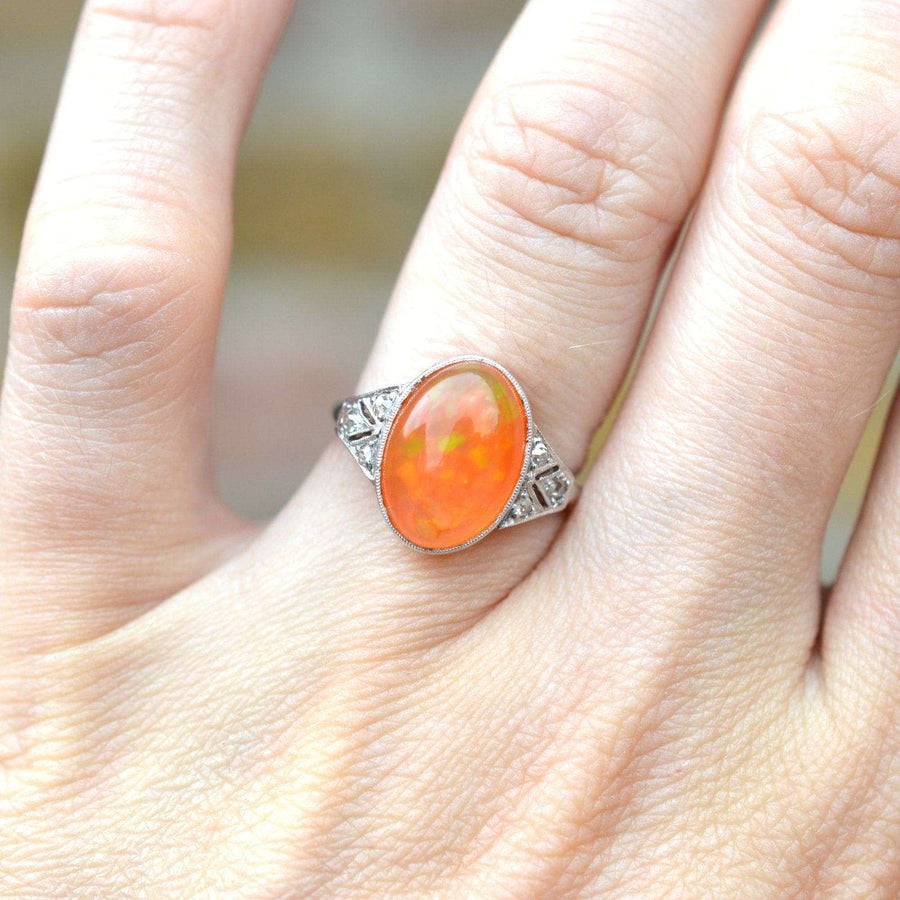 Art Deco 18ct white gold and platinum ring with natural Mexican fire opal and diamonds on a hand.