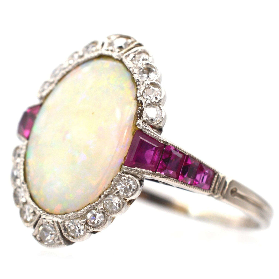 Art Deco 18ct white gold ring featuring a vibrant opal, Burma rubies, and sparkling diamonds in a stunning design.