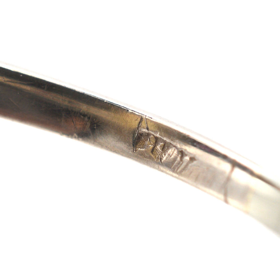 Close-up view of the inner band of an Art Deco ring with engraved marking.