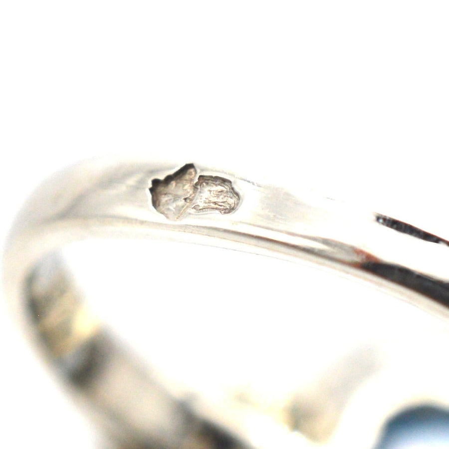 Close-up of the band of Art Deco blue spinel and diamond ring showcasing the stamp details.