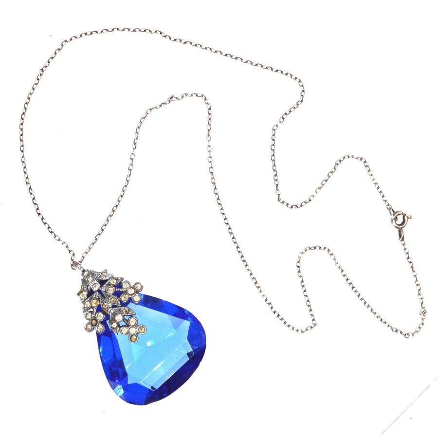 Art Deco blue paste pendant on silver chain with floral white paste setting, showcasing exquisite costume jewelry craftsmanship.