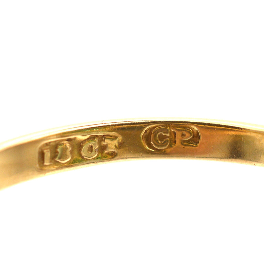 Close-up of the stamp on an 18ct gold ring, displaying quality stamps for authenticity.