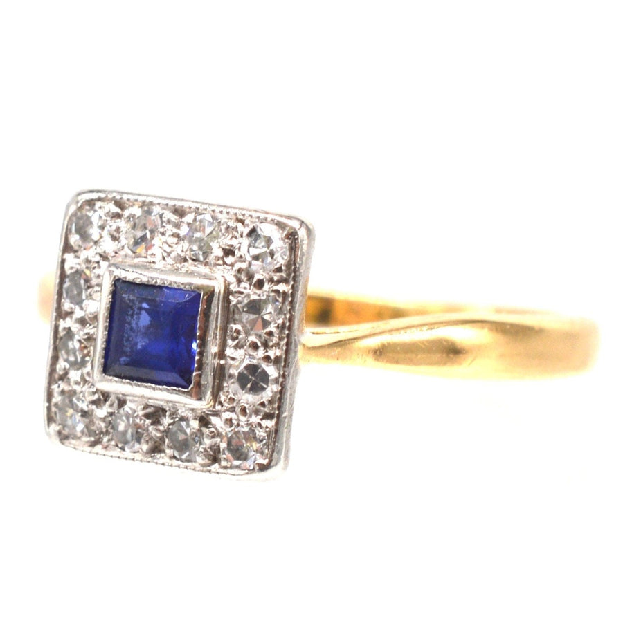Art Deco platinum and 18ct gold sapphire and diamond square cluster ring, vibrant blue sapphire at center.