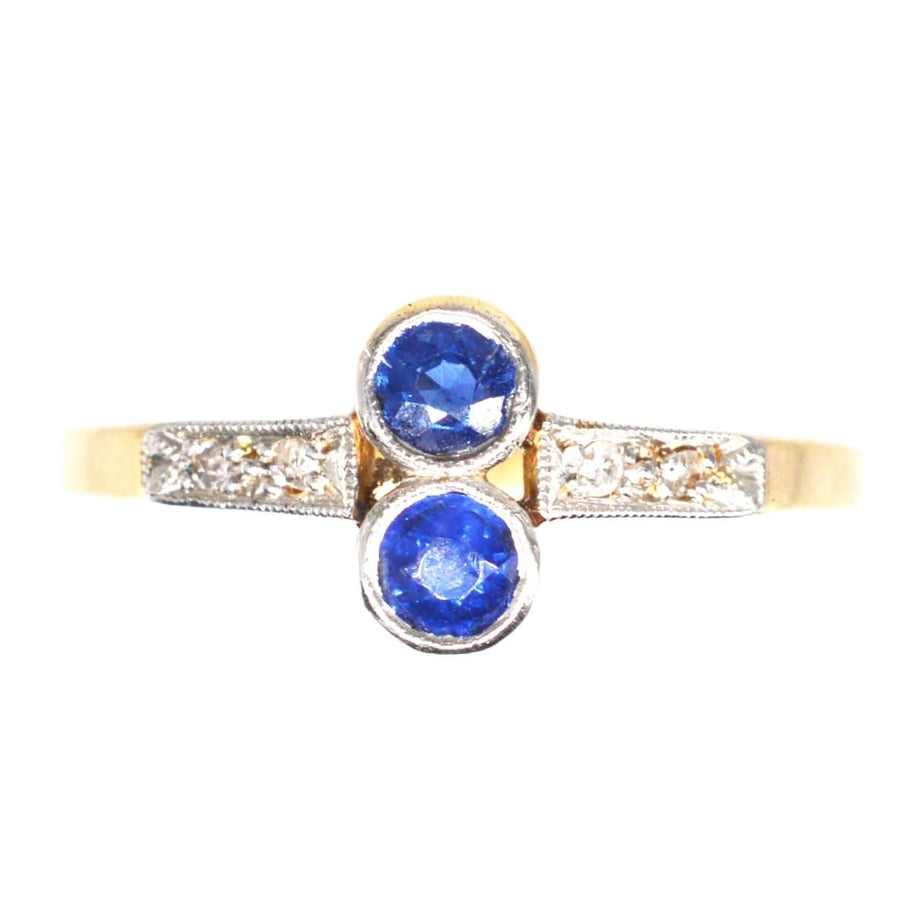 Art Deco platinum and 18ct gold ring featuring two vibrant sapphires and diamond accents, perfect for engagement or September birthdays.