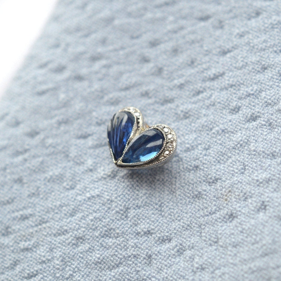 Belle Époque carved cabochon sapphire and diamond heart tie pin displayed on a textured fabric background.