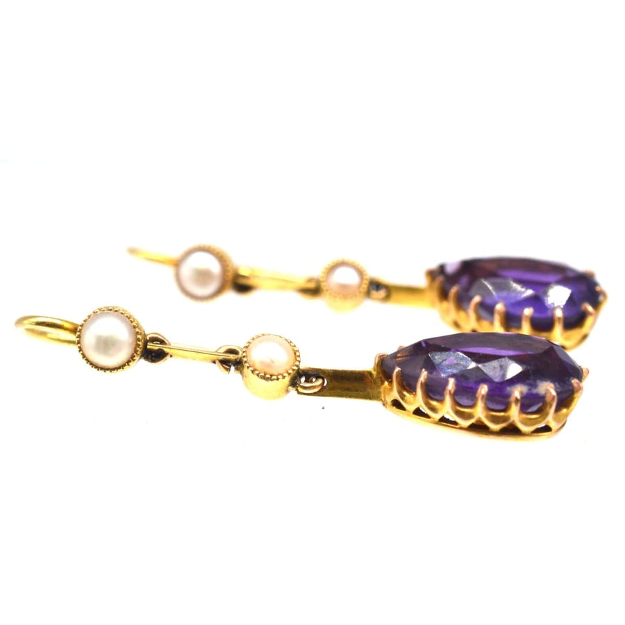 Edwardian 15ct gold drop earrings featuring pear-shaped amethyst and split pearls in a stylish design.