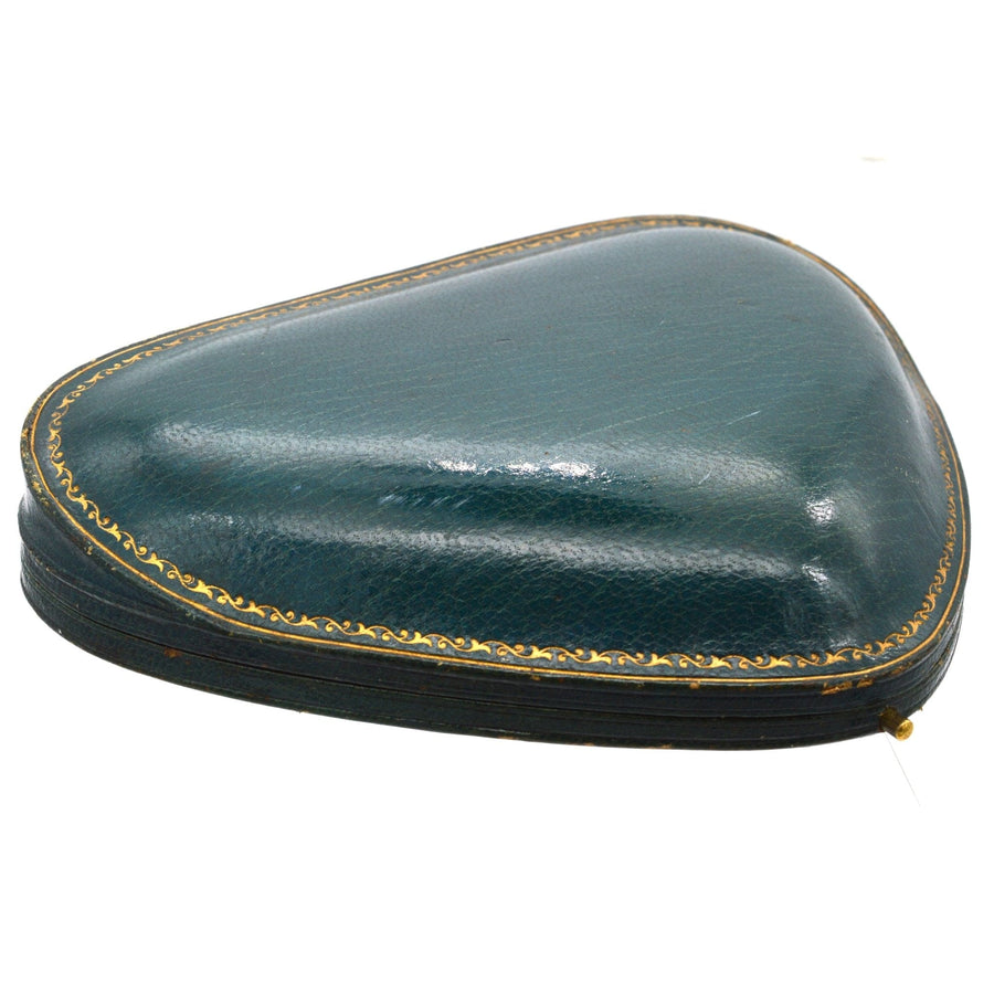 Antique Edwardian green leather case for a diamond and pearl necklace, featuring gold trim and a classic triangular shape.