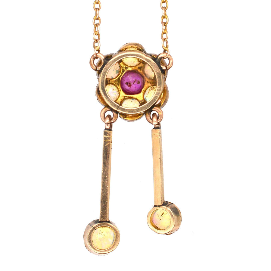 Edwardian 15ct gold pendant featuring opals and ruby, with double drop design and chain, perfect for antique jewelry lovers.