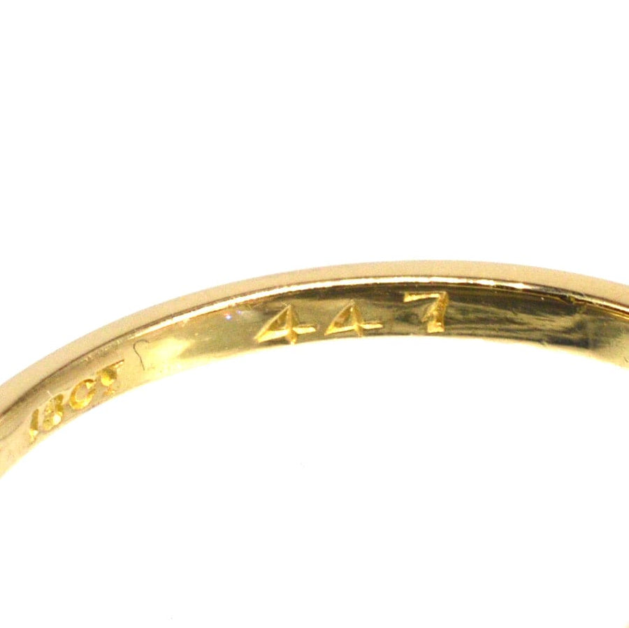 Close-up of the inside of an Edwardian 18ct gold and platinum ring showing stamp details.
